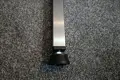 A black plastic threaded square tube insert with an adjustable foot attached. Fitted into a square metal tube.