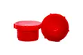 Two red plastic metric threaded plugs. One standing and one on its side.