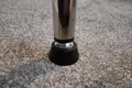 A chrome tube fitted with a black plastic threaded insert with an adjustable foot attached.