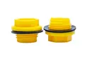 Two Yellow plastic BSP threaded plugs with rubber sealing washers. Both standing on opposite ends.