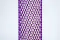 Purple plastic protective netting, stretched over a tube.