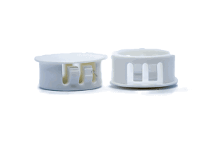 Two black plastic blanking plugs. Both standing up, showing opposite ends.