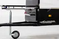 Side view of a mobile BBQ unit with a close-up on the tow bar area, featuring a red PVC dip moulded handle grip mounted on a vertical black panel, highlighting its straight-sided, flexible design.