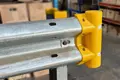 Pedestrian end safety cap fitted to armco barrier. Yellow cap with rounded safety end with reflectors.