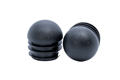 Two black plastic round tube inserts with a domed top. One standing up and one on its side, facing the camera.