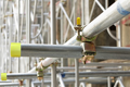 Close up of scaffolding pole structure highlighting yellow protection caps.
