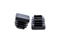 Two black plastic internal feet, one upright and one upside down showing the ribs.