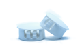 Two white plastic blanking plugs. One standing up, one at an angle.