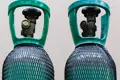 Two gas cylinders covered in black plastic protective netting.