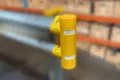 Pedestrian safety cap fitted to armco barrier with blurred background to highlight the yellow safety cap.