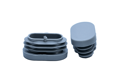 Two grey plastic oval tube inserts. Both standing up, showing opposite ends.