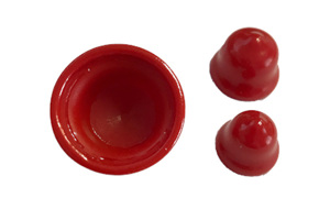 Three red vinyl plugs. Two standing up and one upside down.