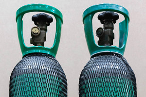 Two gas cylinders covered in black plastic protective netting.