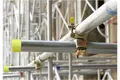 Scaffold pole with clamp forming a structure with yellow plastic protection caps.