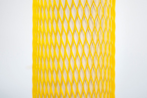 Yellow plastic protective netting, stretched over a tube.